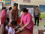 Bagikan Makan siang Gratis untuk anak SD, Kapolres Minsel didampingi ketua Bhayangkari Minsel.